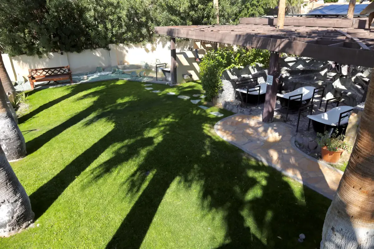 Shaded garden lawn with a pergola and outdoor seating